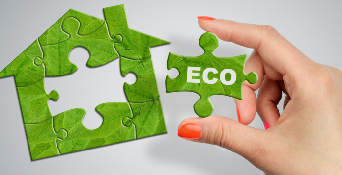 House puzzle with Eco piece held in a woman's hand